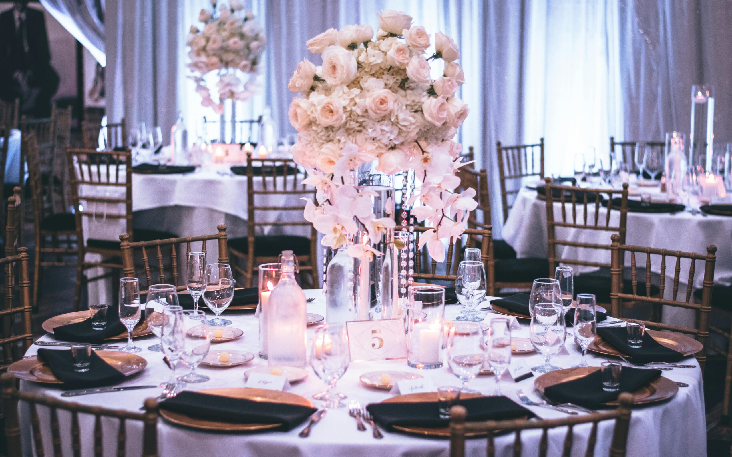 A luxurious wedding dining setup with elegant floral centerpieces and candlelight ambiance.